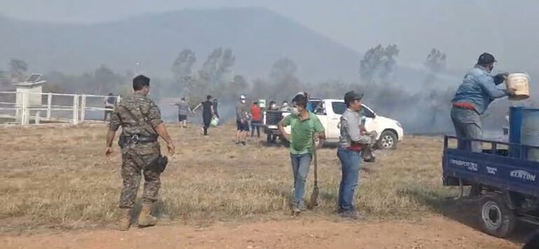 Los vehículos llevaban agua en tambores y los voluntarios con sus baldes procuraban apagar el incendio dentro de la población en Fuerte Olimpo.