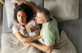 Pareja cansada en la cama, imagen ilustrativa.