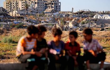 Niños sentados cerca del campamento de refugiados de Nuseirat, en la zona central de la Franja de Gaza.