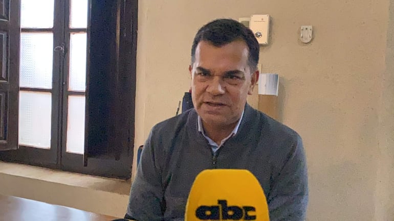 Hombre con cabello corto y suéter gris da declaraciones frente a un micrófono de ABC Color en una oficina.