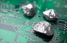 Elemento mineral de tierras raras sobre fondo de placa de circuito electrónico.