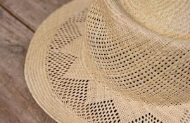 Sombrero de paja trenzado sobre madera, sin personas visibles ni elementos contextualizadores en la imagen.