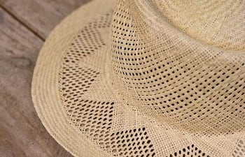 Sombrero de paja trenzado sobre madera, sin personas visibles ni elementos contextualizadores en la imagen.