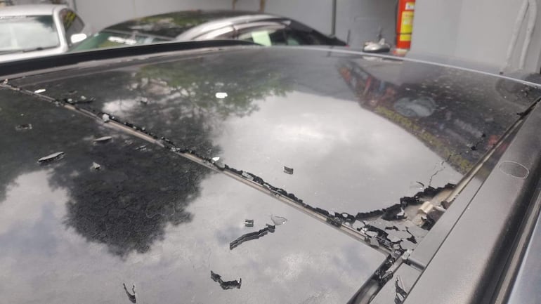 Techo de un vehículo dañado con restos de pintura en un ambiente al aire libre, sin personas visibles.