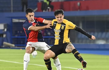 Diego Fernández de Guaraní aguanta la embestida de Marcelo Chaparro en el empate sin goles en La Nueva Olla.