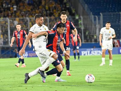 Blas Riveros, jugador de Cerro Porteño, disputa el balón con Mario López, futbolista de Guaraní, en un partido por la fecha 19 del torneo Clausura 2025 de la Primera División de Paraguay en el estadio La Nueva Olla, en Asunción, Paraguay.
