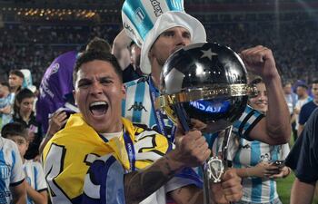 Racing's Colombian midfielder #08 Juan Fernando Quintero celebrate with the trophy after winning the Copa Sudamericana final football match between Argentina's Racing and Brazil's Cruzeiro at La Nueva Olla Stadium in Asuncion on November 23, 2024. (Photo by JUAN MABROMATA / AFP)