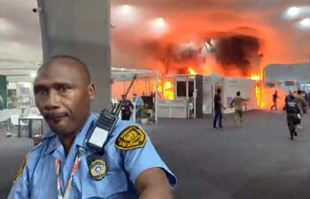 This screen grab taken from AFPTV video footage shows emergency crews battling a fire that broke out at a pavilion inside the venue of the COP30 UN Climate Change Conference in Belem, Para state, Brazil, on November 20, 2025. A fire erupted at a pavilion inside the venue of the UN's climate talks in Brazil on Thursday, prompting panicked delegates to run for the exits, AFP journalists said. Emergency crews rushed to try to put out the blaze as smoke engulfed the corridor. (Photo by AFPTV / AFP)