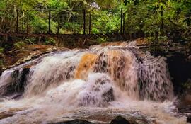 Imponente cortina de agua en el Salto Mirian Mabel con su puente colgante.