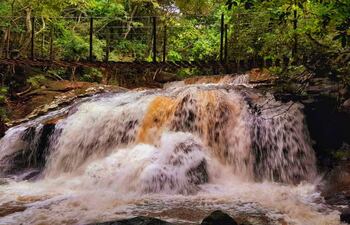 Imponente cortina de agua en el Salto Mirian Mabel con su puente colgante.