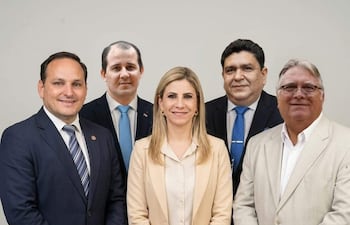 Marcelo Salinas en traje oscuro sonriente, Roya Torres con blusa clara y chaqueta, todos en un entorno formal.