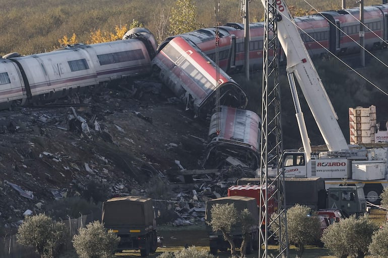  Camiones del ejército y grúas pesadas trabajan en los convoyes de los trenes de Renfe e Iryo que colisionaron en Urda (Toledo) un día después del suceso.
