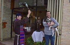 El hermano franciscano Ramón Arévalos bendice a Rufina, una bulldog que llegó en compañía de su familia hasta el convento San Pío de Pietrelcina, en el barrio Trinidad de Asunción.