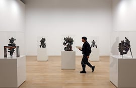 Un miembro de los medios observa una obra del artista argentino Adrián Villar Rojas durante una vista previa para la prensa de la exposición "Machine Love: Video Game, AI and Contemporary Art" en el Museo de Arte Mori en Tokio, Japón.