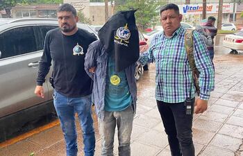 Los agentes intervinientes aparecen con el detenido frente a la base de Interpol en Ciudad del Este.