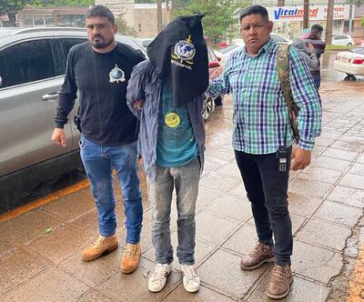 Los agentes intervinientes aparecen con el detenido frente a la base de Interpol en Ciudad del Este.