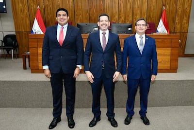 Raúl Latorre y Hugo Meza en trajes oscuros con sonrisas, flanquean a Pastor Vera en un ambiente legislativo oficial.
