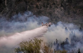 Una aeronave rocía agua para extinguir un incendio forestal en el Monte Pirque, en El Hoyo, en la región patagónica de la provincia de Chubut, Argentina, el 10 de enero de 2026.