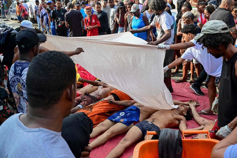Pobladores apilan cadáveres en la plaza Sao Lucas en la Vila Cruzeiro de la favela Penha,  en Río de Janeiro, Brasil.