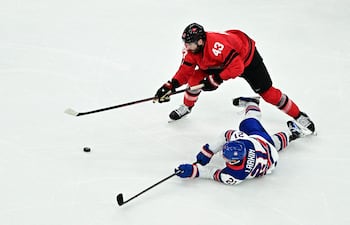 - El canadiense #43 Thomas Wilson (izq.) lucha por el puck con el estadounidense #21 Dylan Larkin durante el partido por la medalla de oro de hockey sobre hielo masculino entre Canadá y Estados Unidos en el Milano Santagiulia Ice Hockey Arena durante los Juegos Olímpicos de Invierno Milano Cortina 2026 en Milán, el 22 de febrero de 2026.