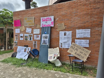Fuertes carteles de protesta y una silla como símbolo ante la falta de espacios en la carrera de Arquitectura de la Universidad Católica.