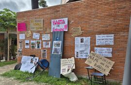 Fuertes carteles de protesta y una silla como símbolo ante la falta de espacios en la carrera de Arquitectura de la Universidad Católica.