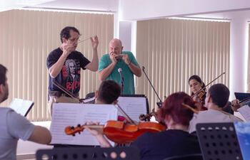 El director Diego Sánchez Haase y el armoniquista José Staneck durante un ensayo con la OSIC.