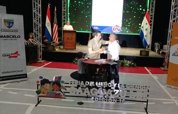 Momento en que el Gobernador de Caaguazú, Marcelo Soto (I) y el director de la Editorial El Lector, Pablo Burián (D), firman convenio de cooperación.