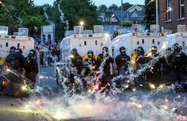 Fuegos artificiales lanzados contra la Policía Antidisturbios iluminaron la calle durante las manifestaciones antiinmigración en Ballymena, Irlanda del Norte.