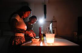 Una familia prepara la cena con ayuda de una vela la pasada noche en la localidad de El Masnou (Barcelona) durante el corte de suministro eléctrico que ha afectado a España y que ha dejado sin servicio el metro y el tranvía de Barcelona y todas las líneas de ferrocarril, y sin red de teléfonos móviles ni internet.