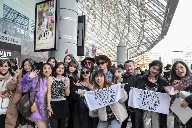 Un grupo de "swifties" chinos posan frente al Tokyo Dome de Japón, donde Taylor Swift iniciará el tramo de su gira asiática.