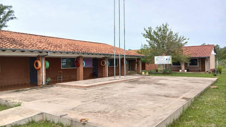 Edificio del Colegio Nacional Mcal. Francisco Solano López, sin personas, rodeado de vegetación y mástiles vacíos.