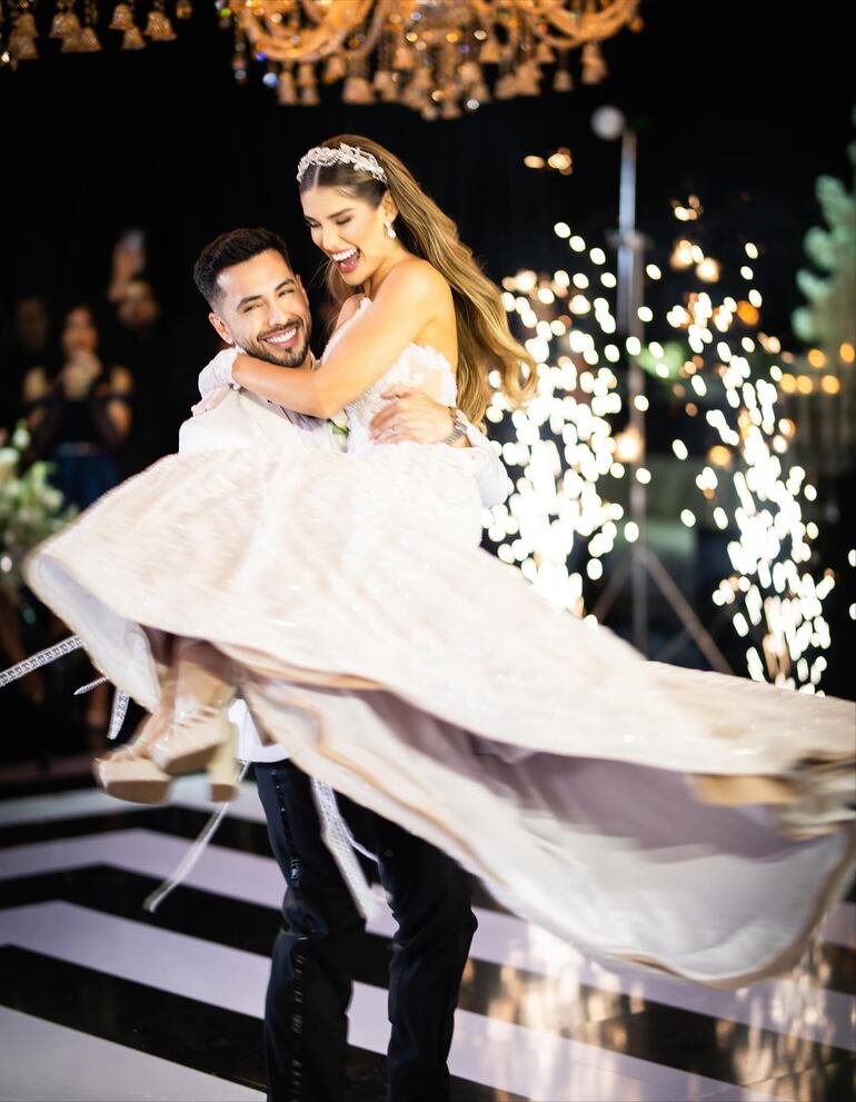 La radiante novia Betha Borba en brazos de su marido Jorge Escobar. (Instagram/Reflejos - Cobertura de eventos)