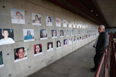 El padre de una de las víctimas del incendio del supermercado Ycuá Bolaños, Rubén Rojas, observa una fotografía de su sobrina fallecida en el desastre, durante la conmemoración del vigésimo primer aniversario de la catástrofe.