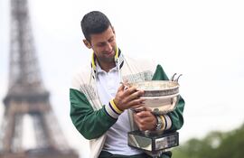 El serbio Novak Djokovic, con el trofeo del Roland Garros en una sesión fotográfica frente a la Torre Eiffel, en París, Francia.