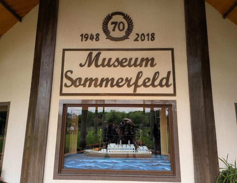 Fachada del Museum Sommerfeld con escudo que muestra '70' y fechas '1948' y '2018', rodeado de áreas verdes.