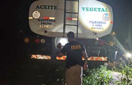 Un policía de Automotores junto a uno de los cisternas supuestamente robados encontrados en el taller de los hermanos camioneros Almirón Acha en Minga Guazú.