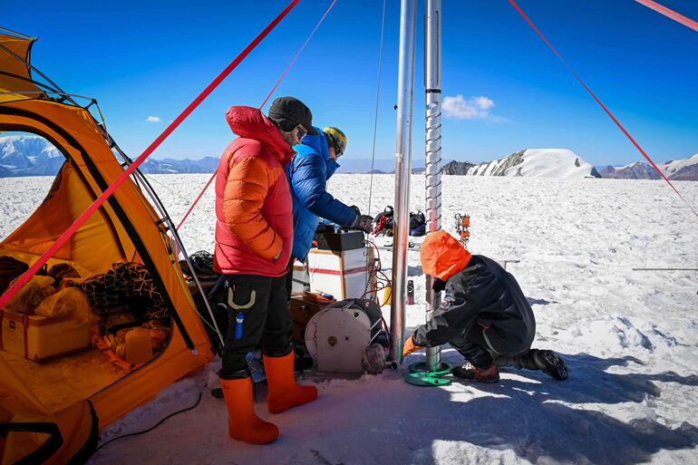 Esta imagen muestra al jefe de la expedición, Evan Miles (chaqueta azul), y al paleoclimatólogo y glaciólogo ruso Stanislav Kutuzov (chaqueta roja), extrayendo una 'zanahoria' (núcleo) de hielo del glaciar de Pamir como parte de la expedición 'Pamir-Ice-Memory', en Kon Chukurbashi, Tayikistán oriental, el 24 de septiembre de 2025.