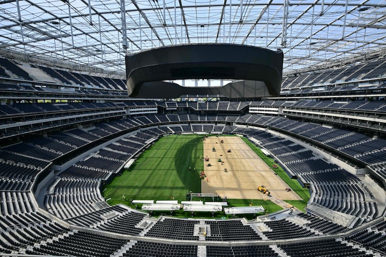 Trabajadores instalan césped en el campo del SoFi Stadium en Inglewood, California, antes de su cambio de nombre temporal a Los Angeles Stadium para el Mundial.
