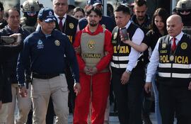 Matías Agustín Ozorio (c), de nacionalidad argentina, es trasladado por integrantes de la Policía Nacional de Perú (PNP) y de Interpol para ser entregado a la Policía Argentina este jueves, en la Base Aérea de Policía Aérea de Perú en Lima (Perú). La PNP entregó a la Policía de Argentina a Ozorio, señalado como presunto cómplice del peruano Tony Janzen Valverde ('Pequeño J') en el reciente triple feminicidio en Buenos Aires de las jóvenes Morena Verdi y Brenda del Castillo, ambas de 20 años, y Lara Gutiérrez, de 15 años.