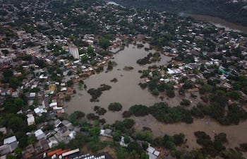 Vista aérea de Barrio San Rafael con viviendas sumergidas y camiones estacionados en medio de inundaciones.