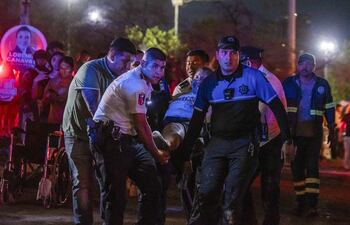 Personal de rescate traslada a personas heridas donde se desplomó un templete durante un acto político de Movimiento Ciudadano (MC), anoche en la ciudad de Monterrey (México).