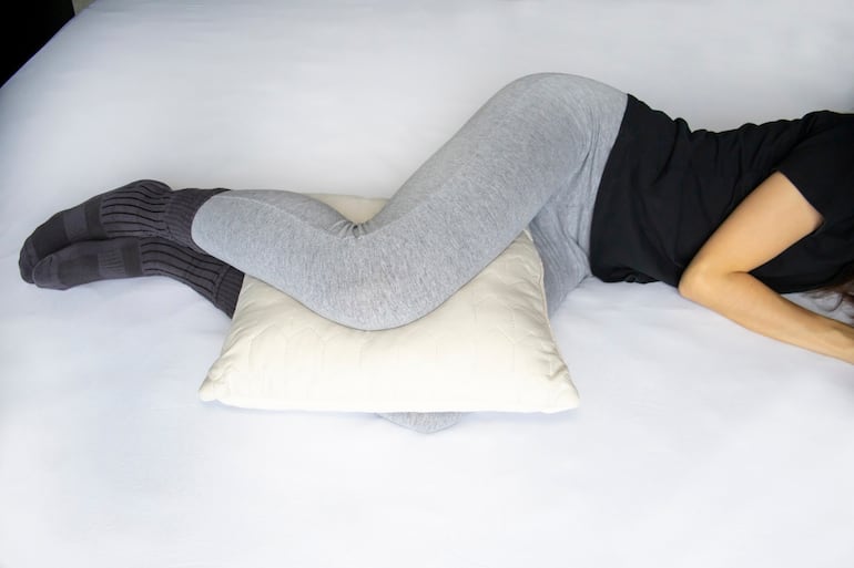 Dormir con una almohada entre las piernas.