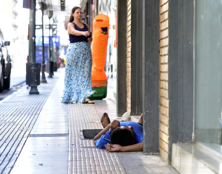 En la calle 25 de mayo, una joven ingresa a un comercio, en cuya vereda se observa un joven durmiendo en el piso, aún con su pipa de crack en la mano. Nada raro en el centro.