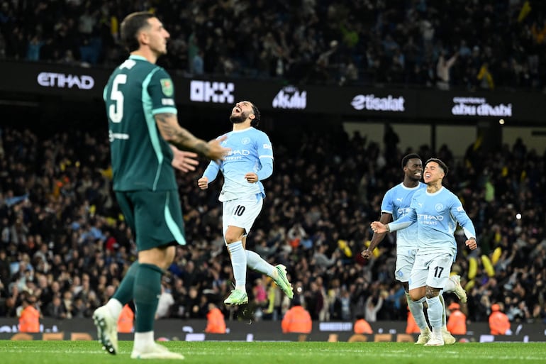 El centrocampista francés, Rayan Cherki, el defensa inglés, Marc Guéhi, y el centrocampista argentino, Enzo Fernández celebran la victoria mientras el defensa inglés del Brighton, Lewis Dunk, reacciona tras fallar un penal durante el partido por la cuarta ronda de la Copa de la Liga de Inglaterra entre el Manchester City y el Brighton and Hove Albion en el estadio Etihad de Mánchester.