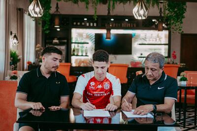 El lateral Alan Vargas firma su contrato en medio del presidente Julio Aldama (derecha) y el gerente deportivo Sebastián Aldama.