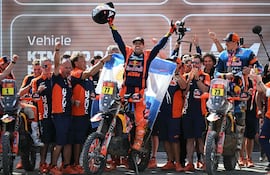 Extraordinario desenlace en motos. Victoria de Luciano Benavides, quien festeja en el podio rodeado de su equipo KTM.