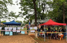 Grupo de estudiantes con carteles de protesta frente al Colegio Nacional Raúl A. Oviedo, bajo carpas de colores y con banderas.