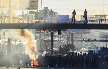 Personas bloquean una avenida este sábado, en El Alto (Bolivia). El convoy de vehículos militares y policiales que despejó parcialmente un camino troncal del altiplano de Bolivia decidió volver a La Paz, tras más de trece horas de trabajo para retirar decenas de montículos de tierra, troncos, piedras y neumáticos quemados usados por los campesinos aimaras para cortar la ruta desde hace once días exigiendo la renuncia del presidente Rodrigo Paz