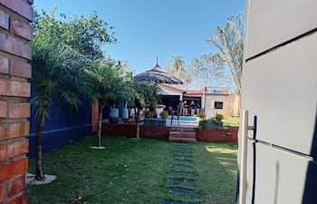 Entorno exterior de una vivienda, con plantas y caminos, en un día soleado y tranquilo.